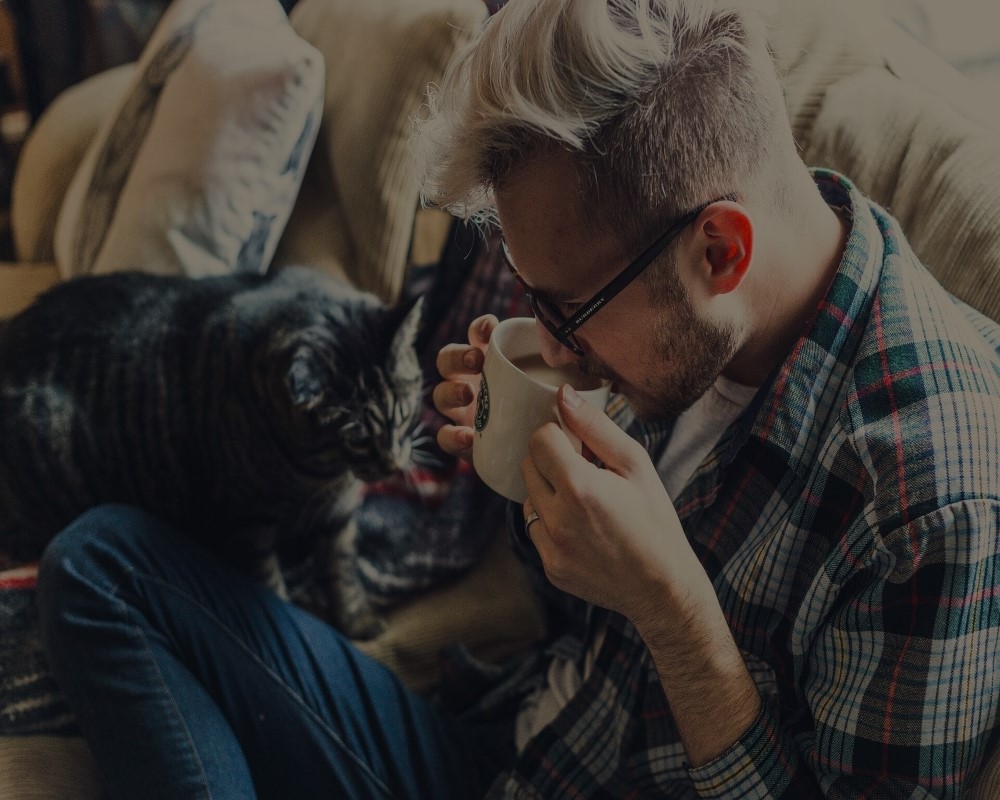 Man drinking coffee with cat